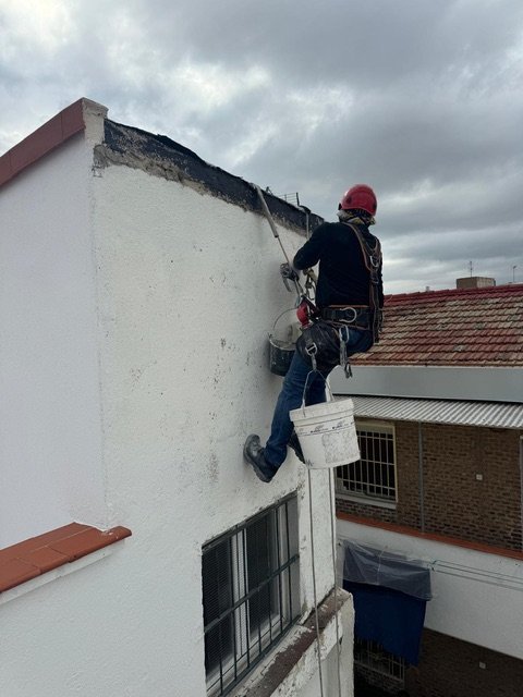 Operario en trabajos verticales sobre fachada